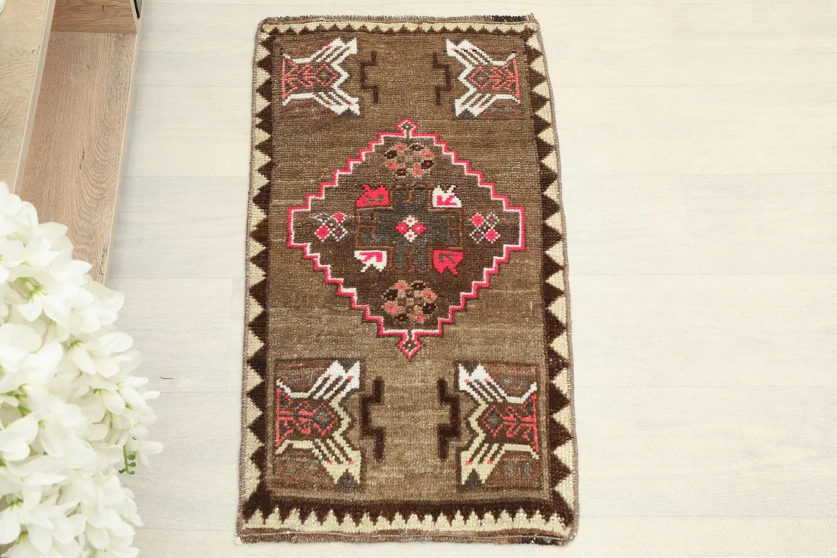 Overhead view of the small brown rug, showcasing its central medallion and corner motifs