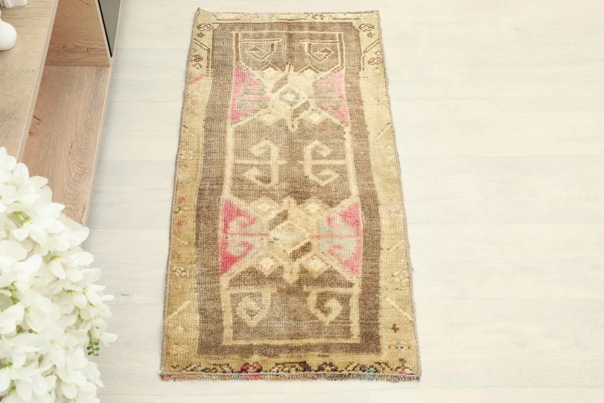 Overhead view of the brown and tan hand-knotted wool rug, highlighting its geometric patterns.