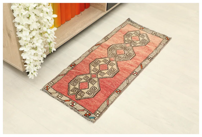 Full top view of the rose and gray geometric vintage Anatolian doormat on a white background.