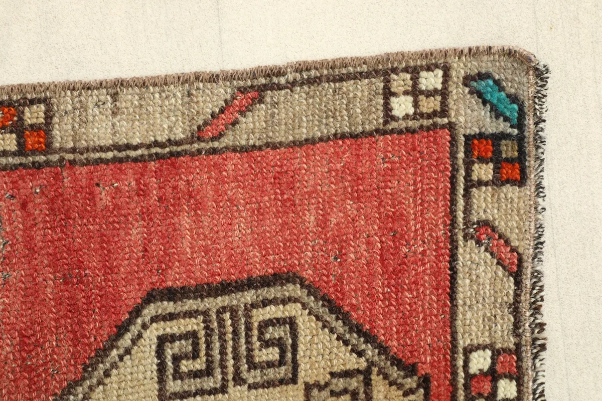 Close-up of the rug's border design, showing the geometric patterns and the low pile texture.