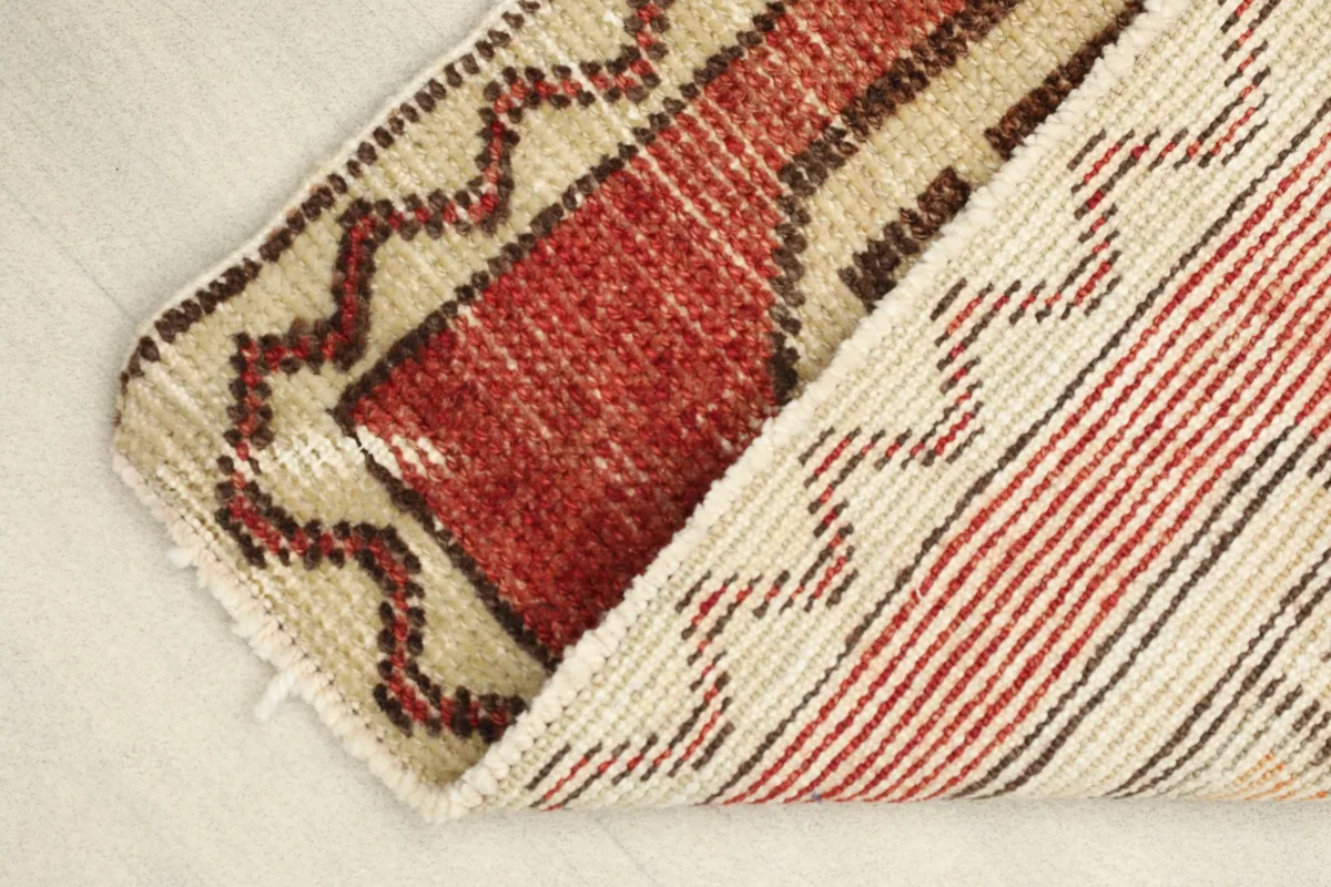View of the back of the hand-knotted wool rug, showing its construction and striped pattern.