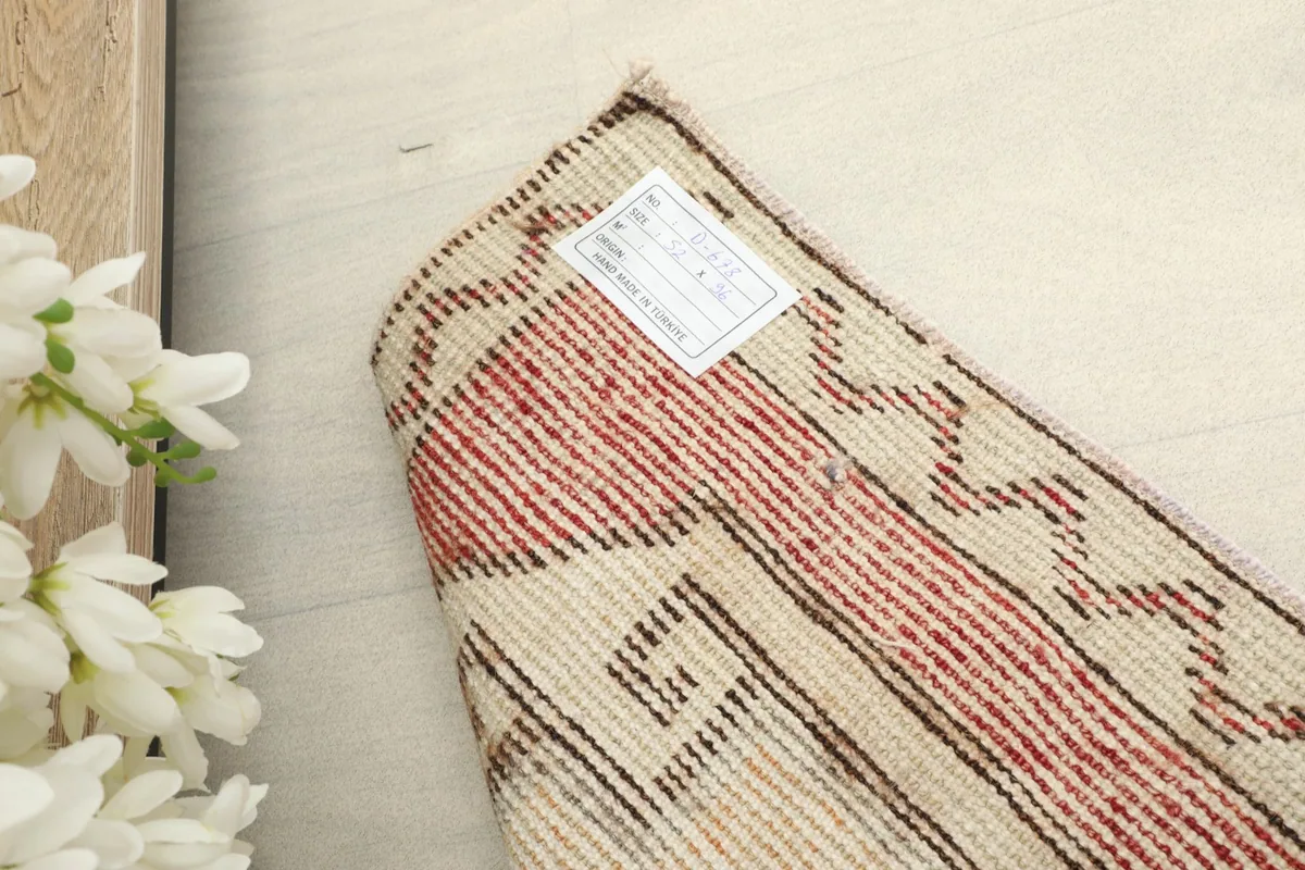 Close-up of the back of the rug with a label, revealing the tight hand-knotted wool on cotton foundation.