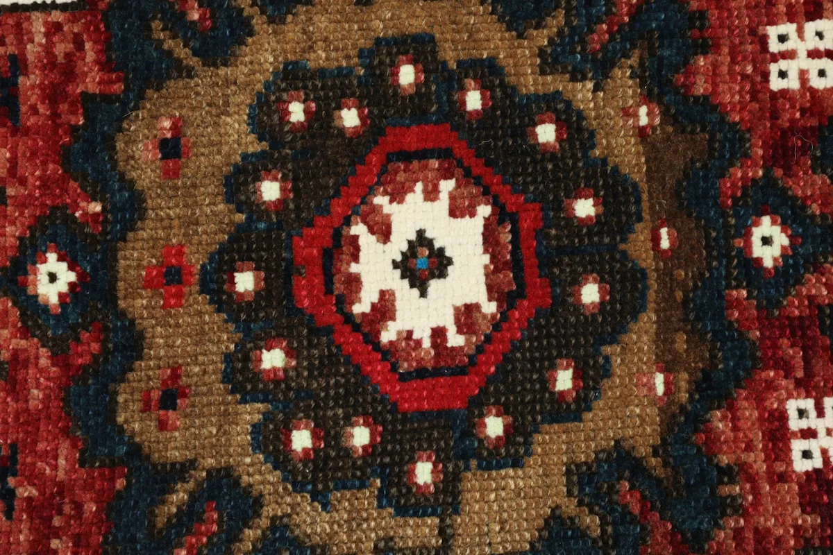 Detailed view of the rug's wool pile and intricate knotting of the medallion