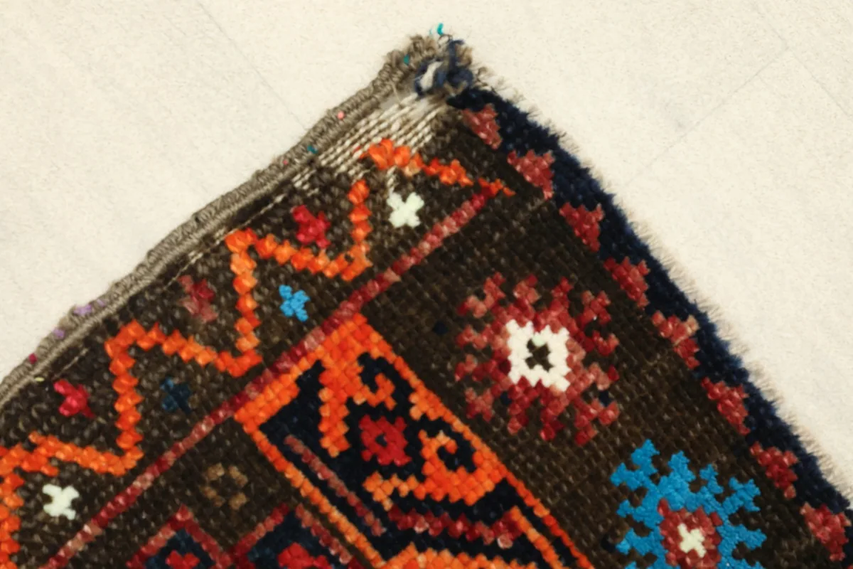 Corner detail showing the patterned border in orange, blue, and cream