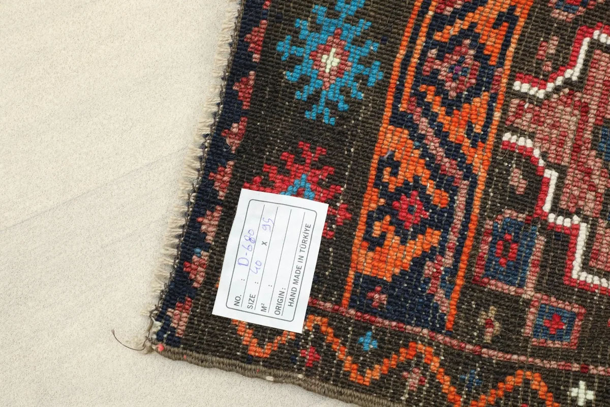 Close-up of the rug's corner with the product tag, showing 'Hand Made in Turkey'