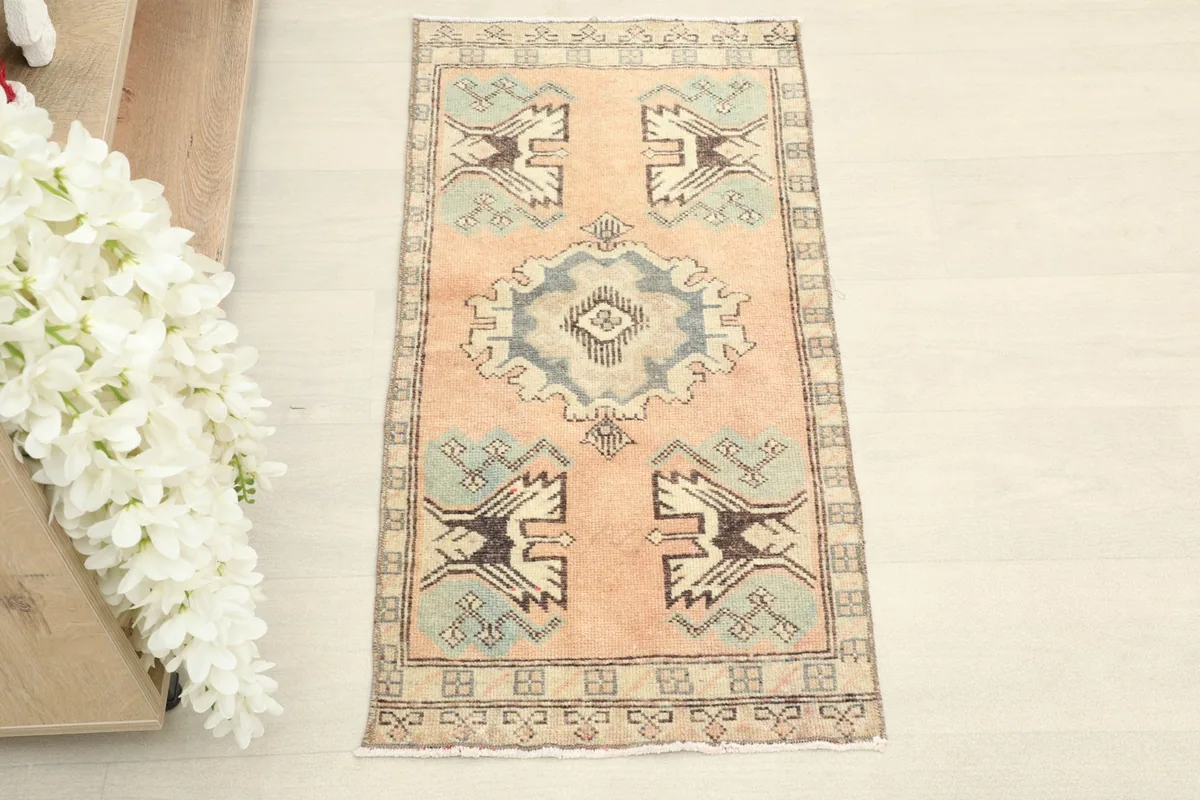 Overhead view showcasing the rose field, gray medallion, and geometric motifs of the rug