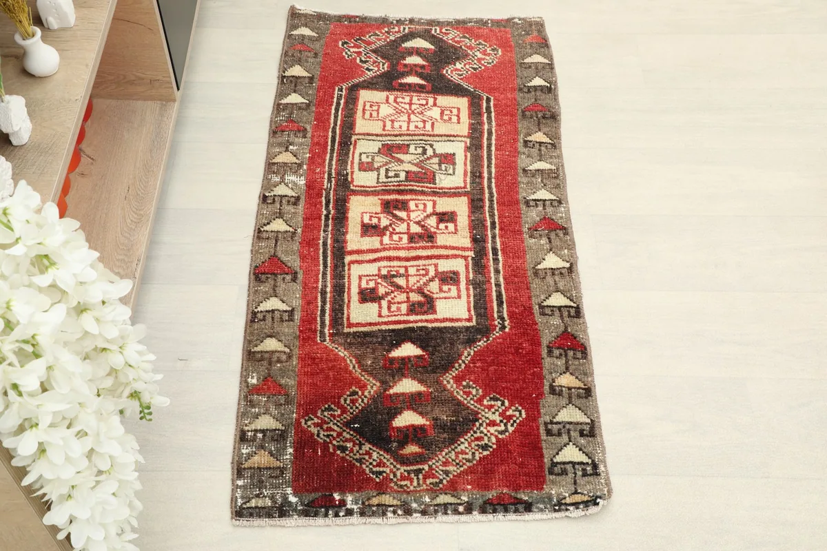 Overhead view of the hand-knotted red doormat, showing its full length and width.