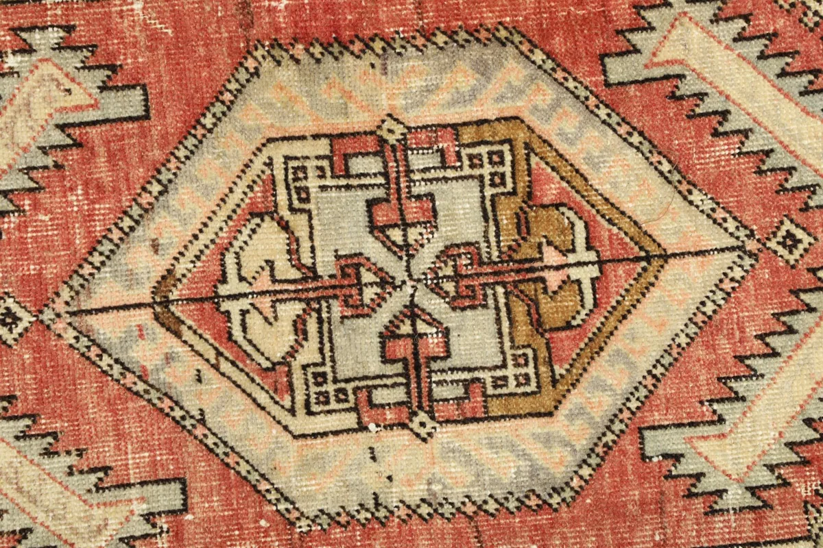 Detailed view of the central tribal medallion and faded red background.