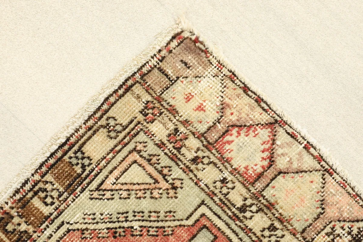Corner detail of the rug showing the outer border and part of the main field.