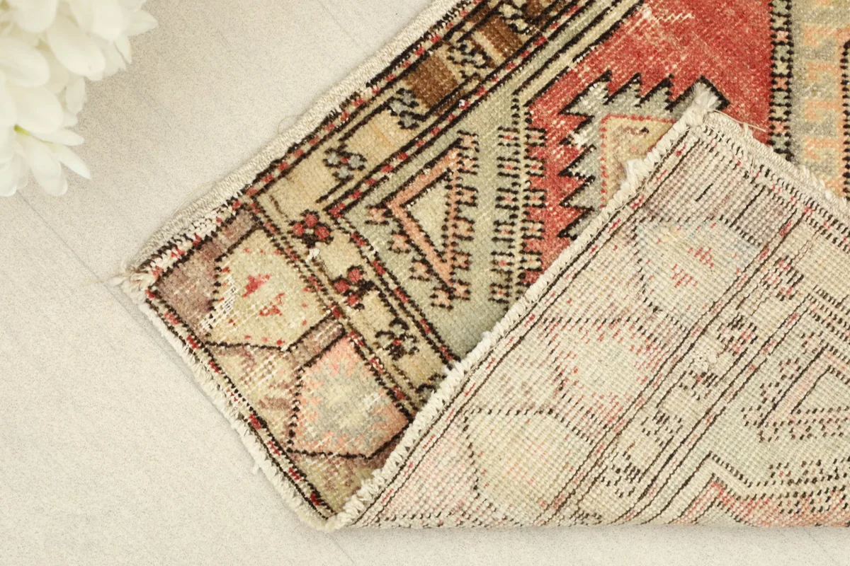 View showing the folded corner of the rug, revealing its cotton foundation and hand-knotted construction.