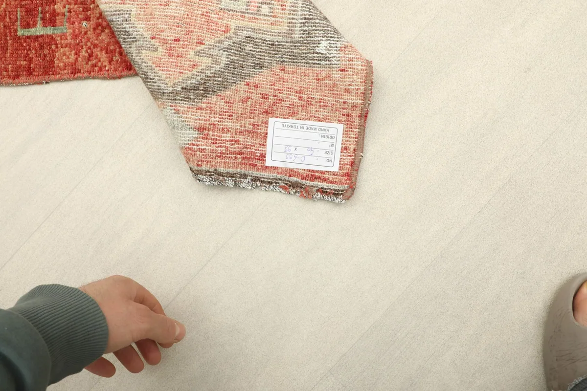 Underside of the rug with its label, showing the hand-knotted construction and cotton foundation.