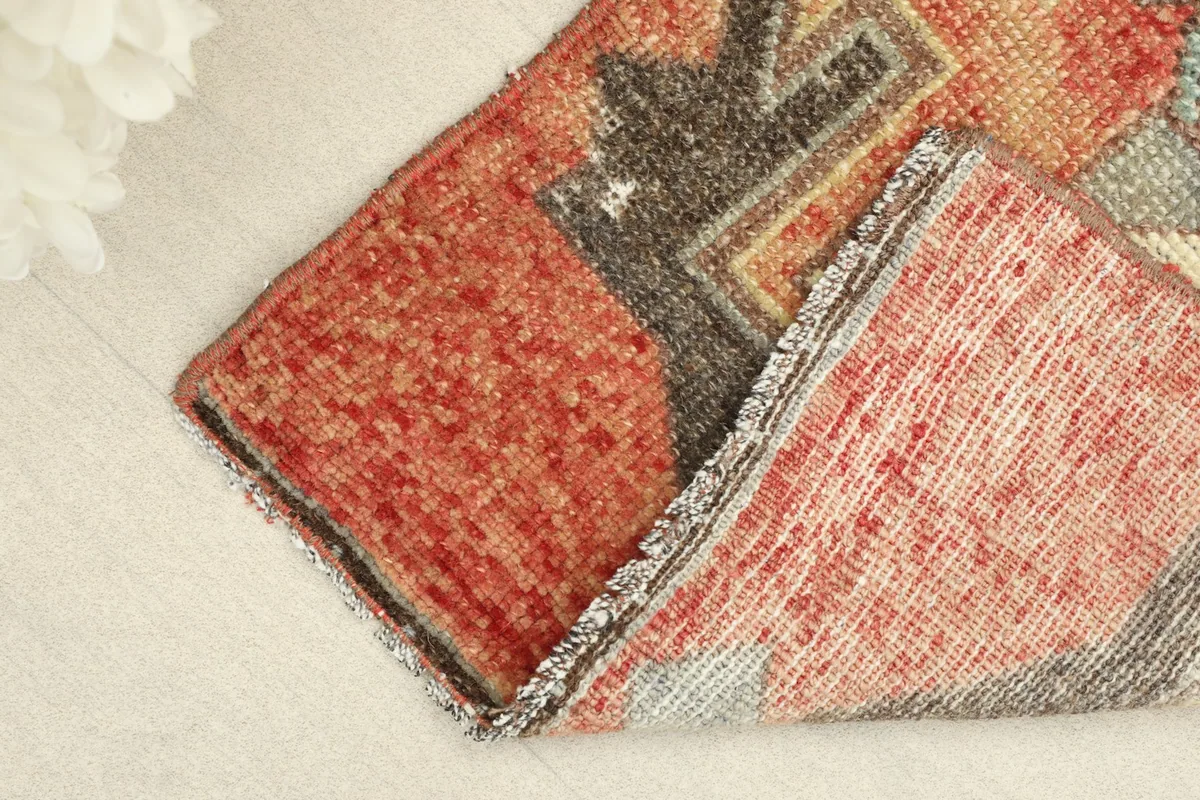 Rug folded to show the front and back, revealing the cotton foundation and wool pile texture.