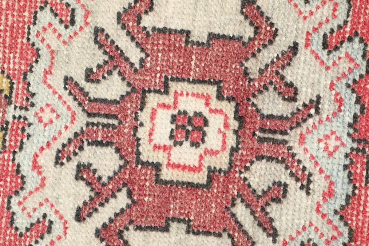 Detailed view of the hand-knotted wool pile, highlighting the intricate tribal motifs and colors.
