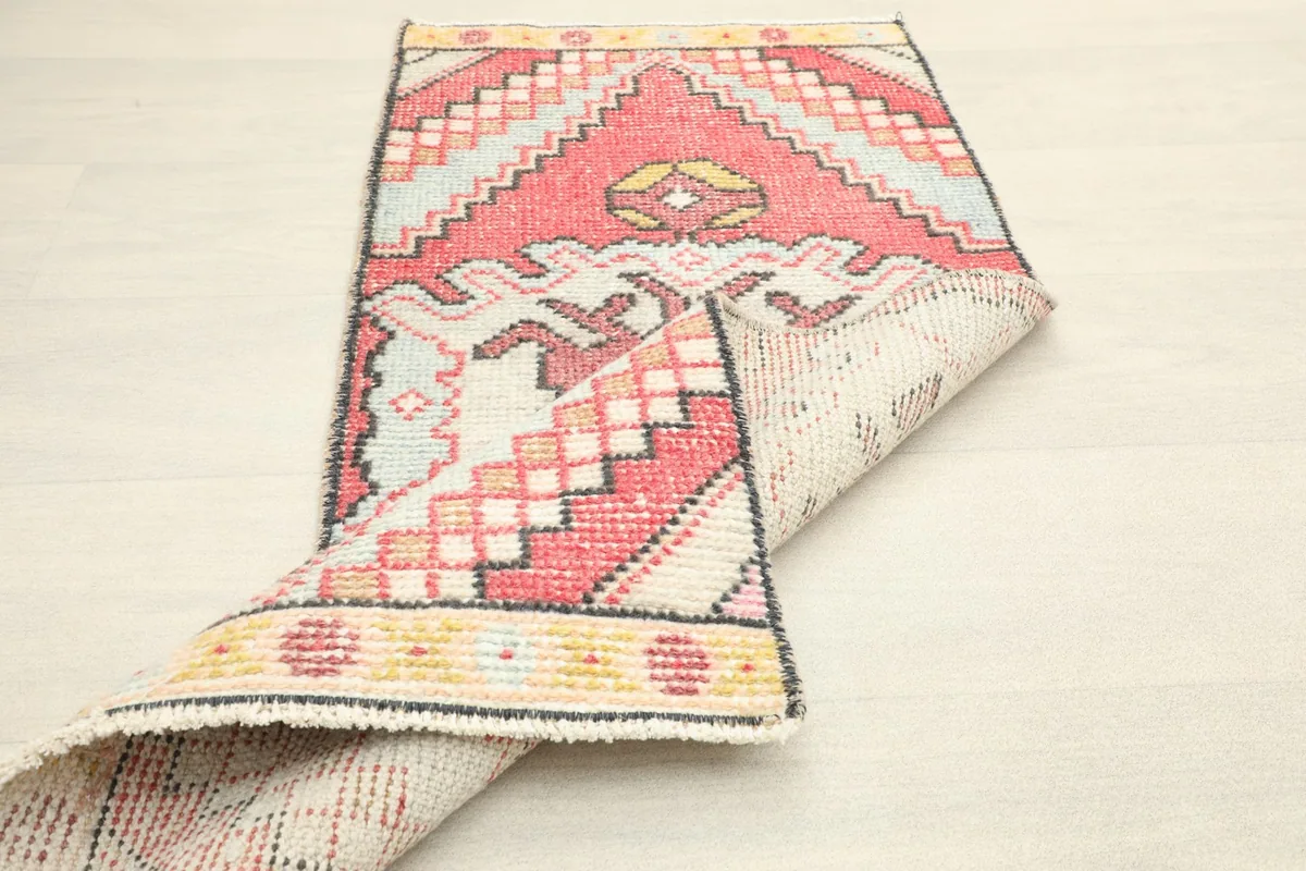 Rug partially folded, showing the flexibility and the texture of both the pile and the foundation.