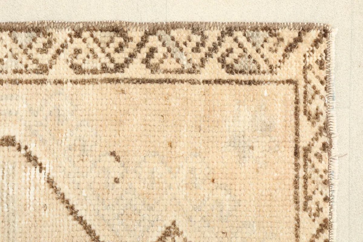 Close-up of the upper border, revealing the brown tribal motifs and tan background
