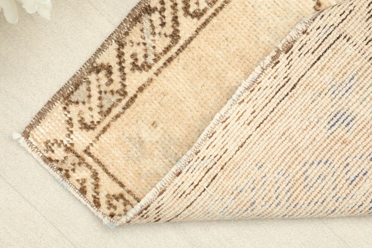 View of the rug's back, showing the cotton foundation and hand-knotted construction