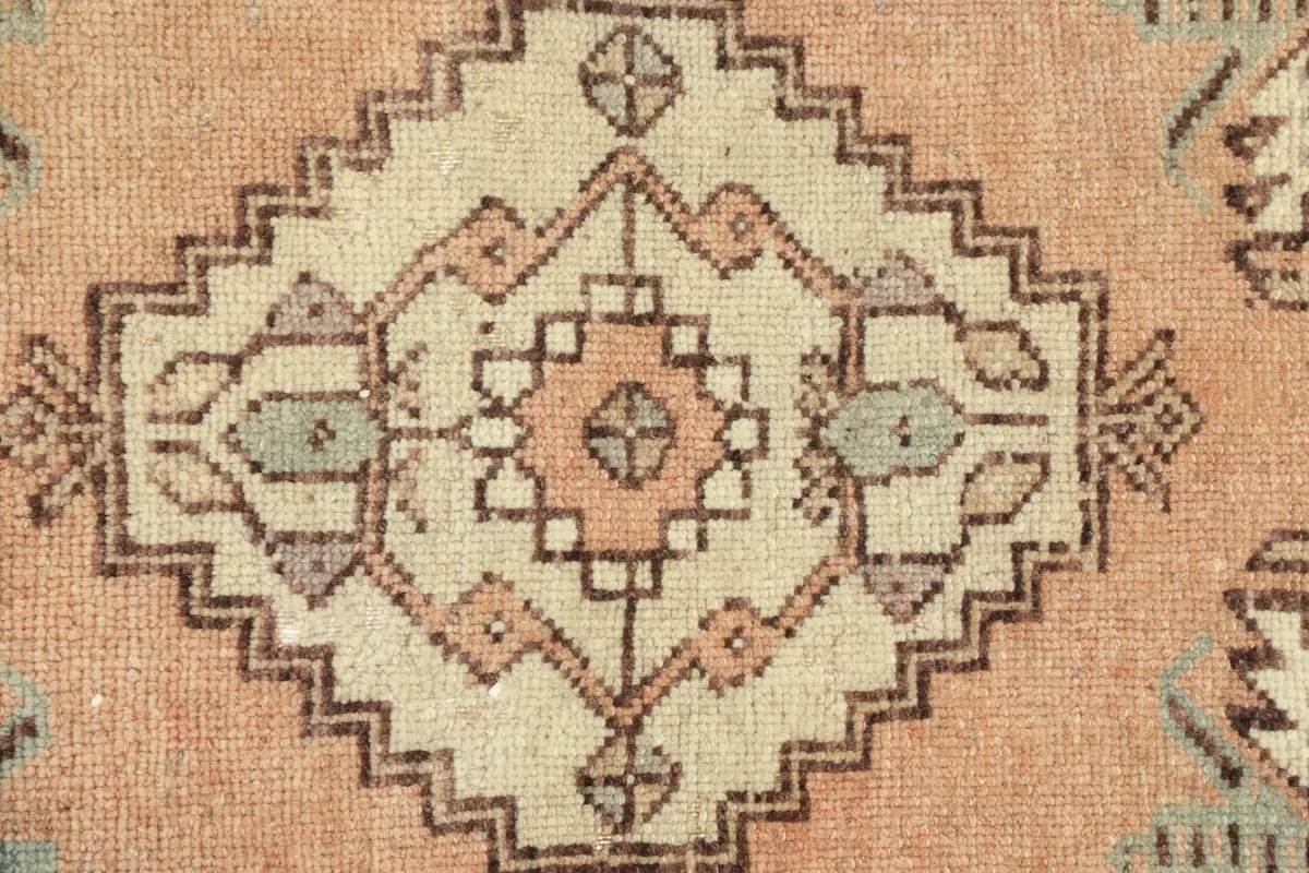 Detailed shot of the rug's central design, highlighting the intricate knotting and color variations.