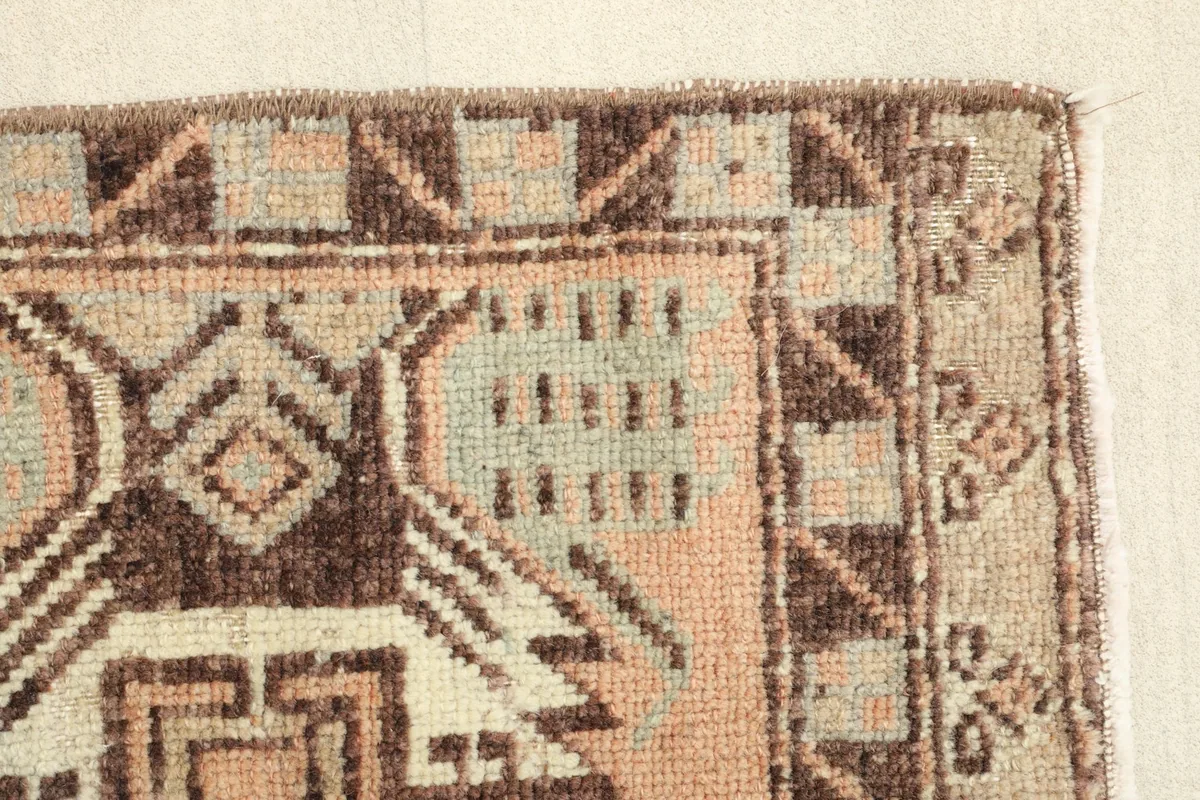 Close-up of a section of the rug, revealing the texture of the wool pile and the geometric elements.