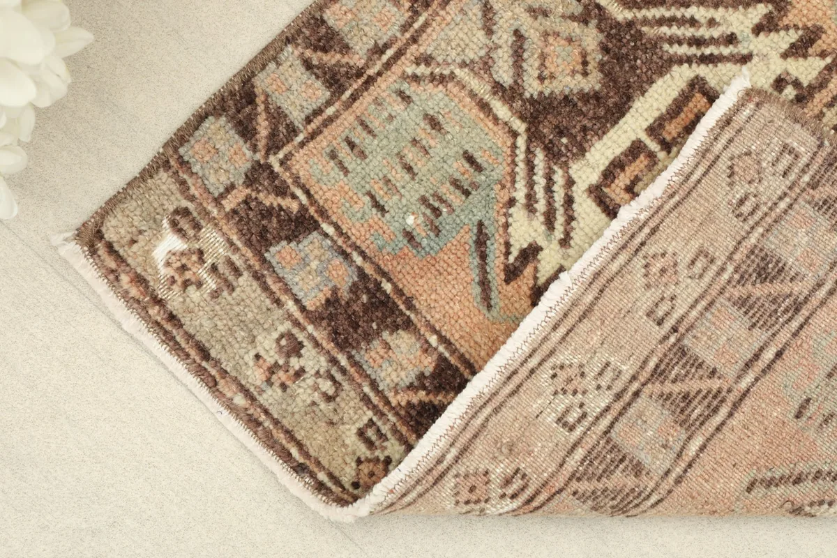View of the rug's low pile, with a section gently folded to show its flexibility and thickness.