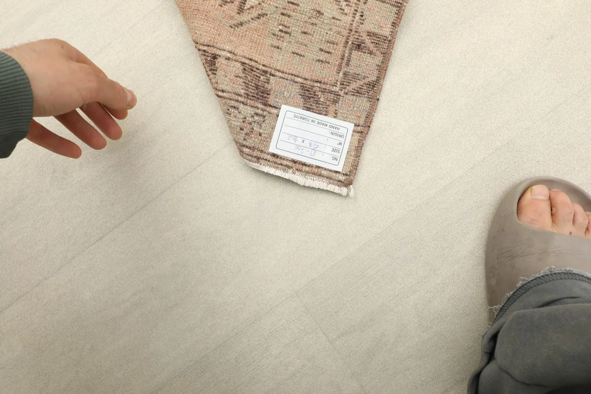Underside of the rug with a label, showing the cotton foundation and fine knotting.
