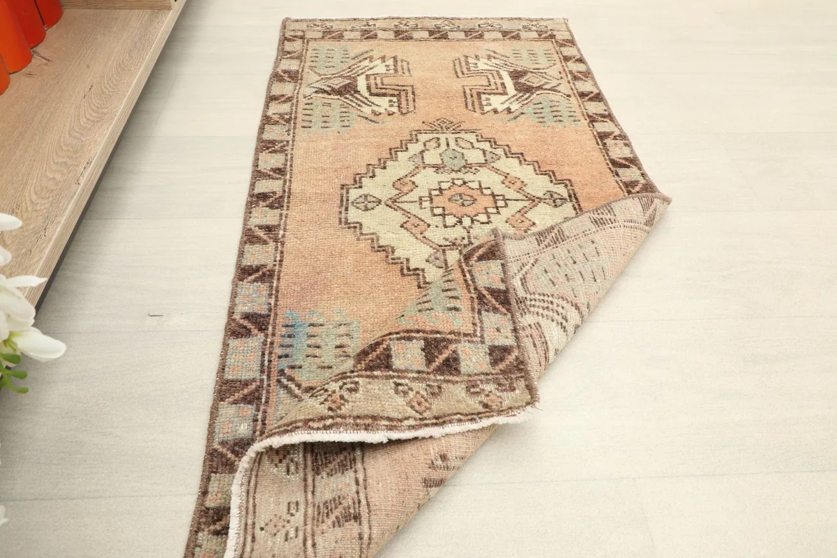 The rug partially folded, demonstrating its pliable nature and the hand-knotted construction.