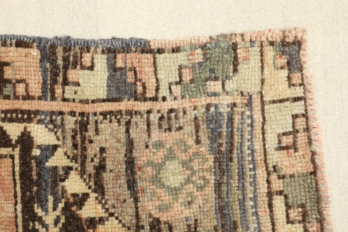 Close-up of the rug's border, showcasing the hand-knotted texture and varied colors.