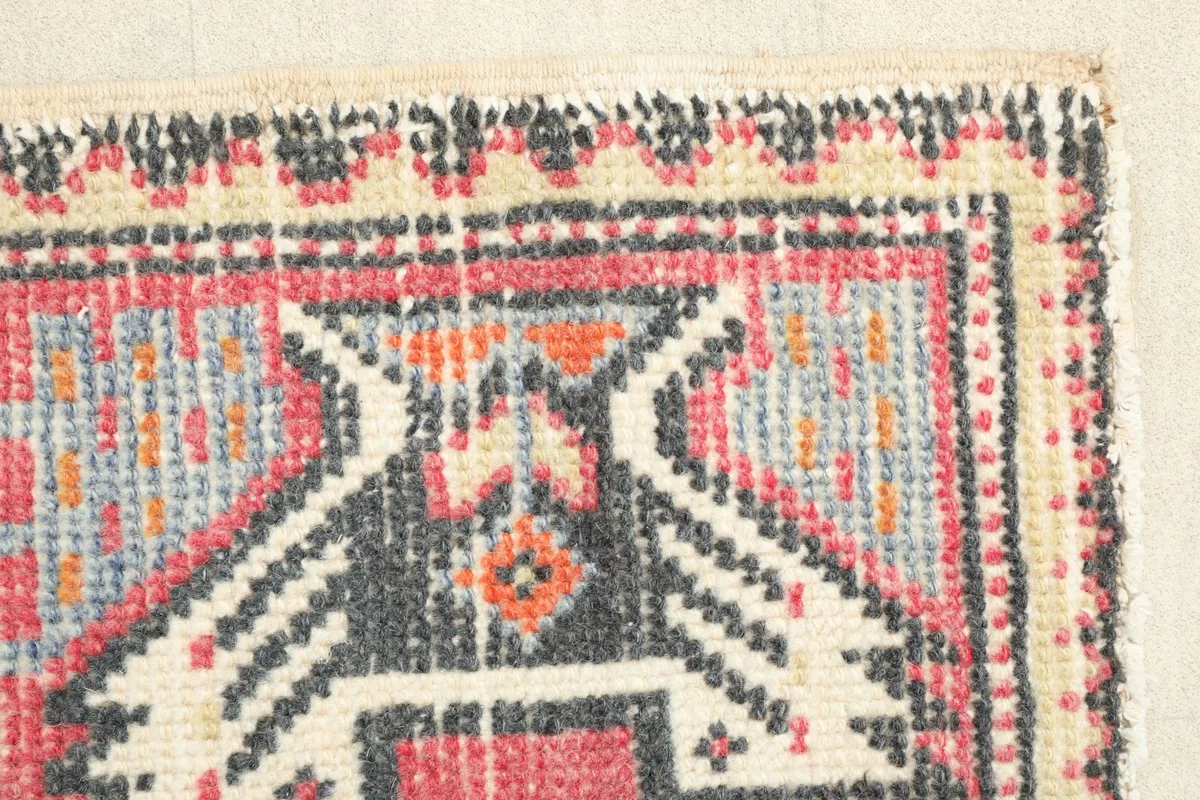 Close-up of the rug's border and a section of the main field, revealing the hand-knotted texture.