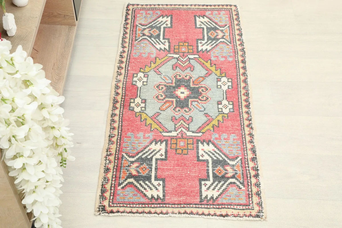 Straight overhead view of the hand-knotted wool doormat, showing its central blue motif and rose field.