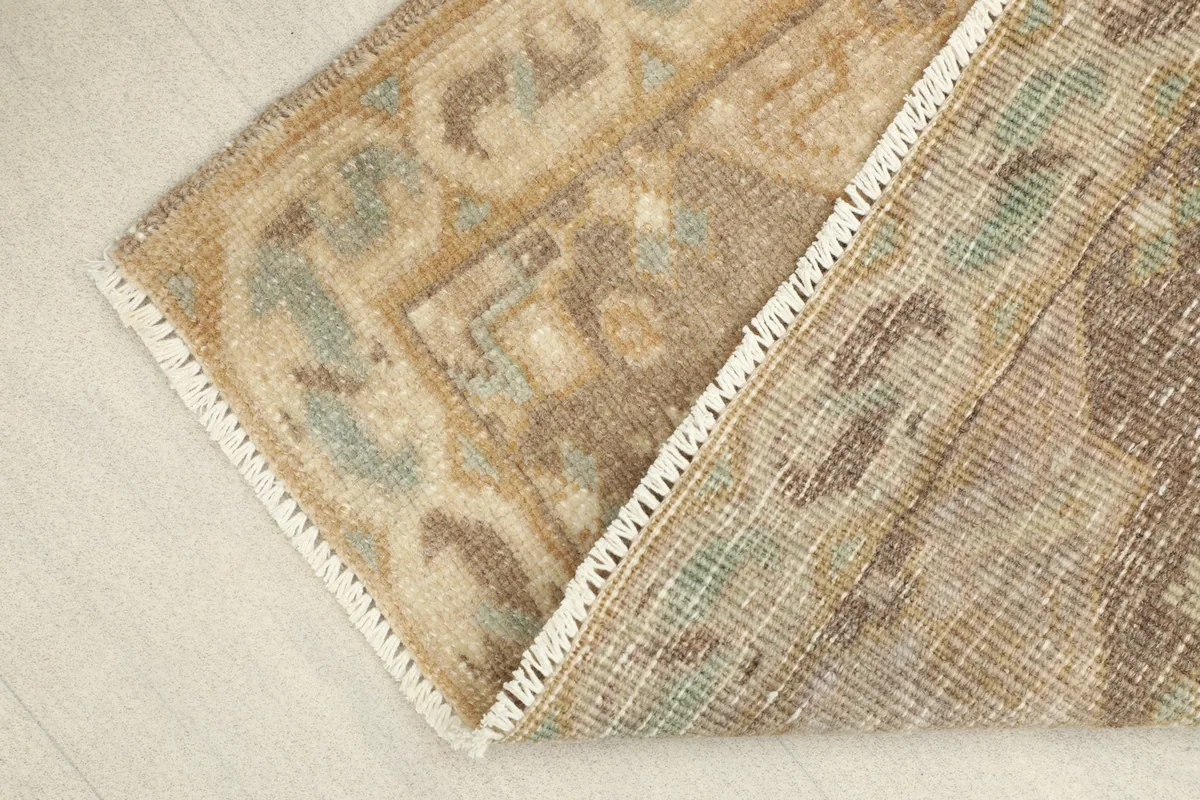 View of the rug's back and its hand-knotted cotton foundation, with pile folded over