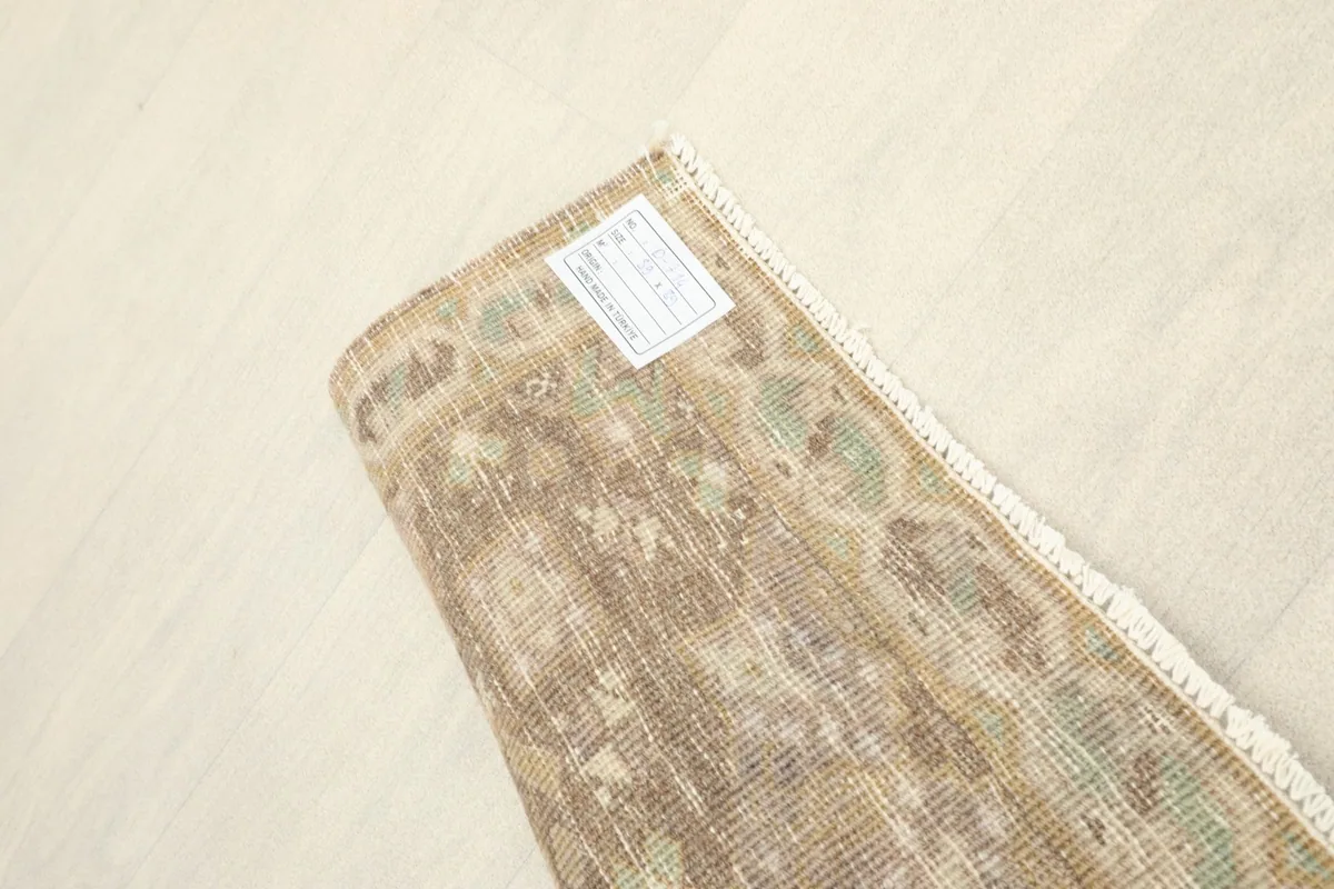 Close-up of the rug's reverse side, showing the intricate knotting and label