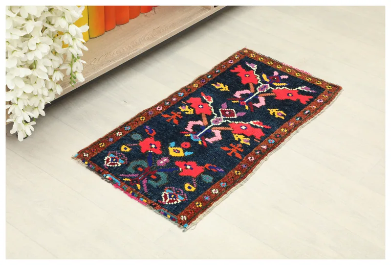 Full overhead view of the navy and red tribal geometric rug on a white background
