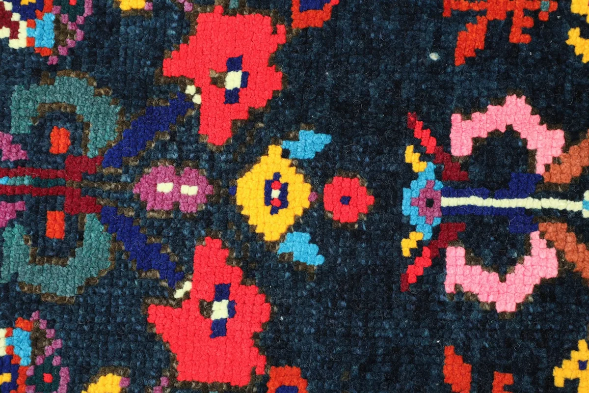 Close-up detail of the hand-knotted wool pile and intricate geometric patterns