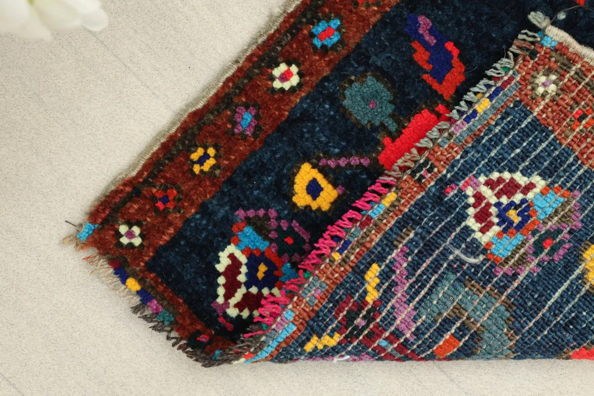 Folded corner of the rug, revealing the dense wool pile and sturdy cotton foundation