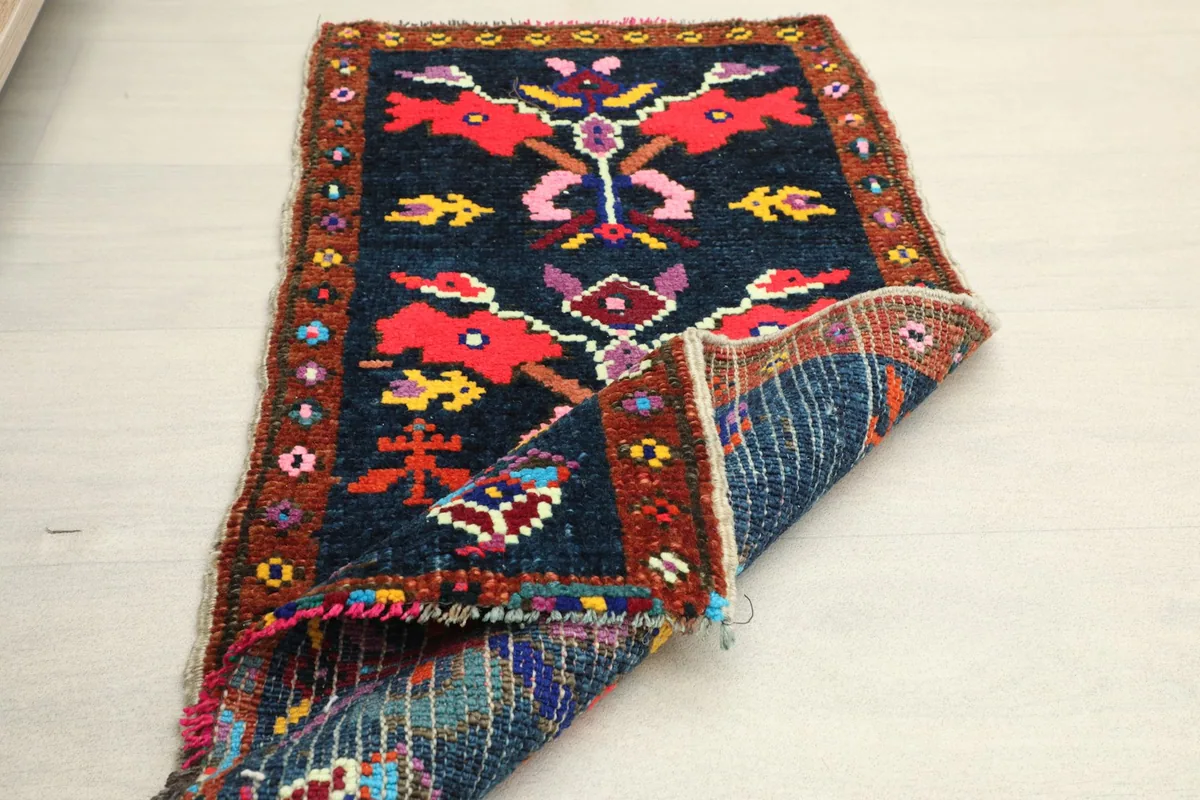 Rug partially folded, showcasing the reverse side's woven texture and foundation
