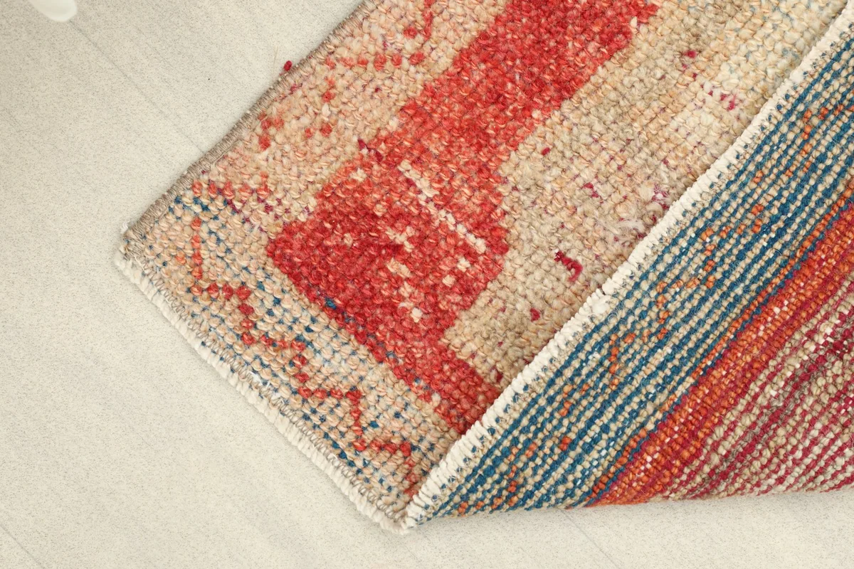 View showing the folded rug, revealing the tightly woven cotton foundation and wool pile.