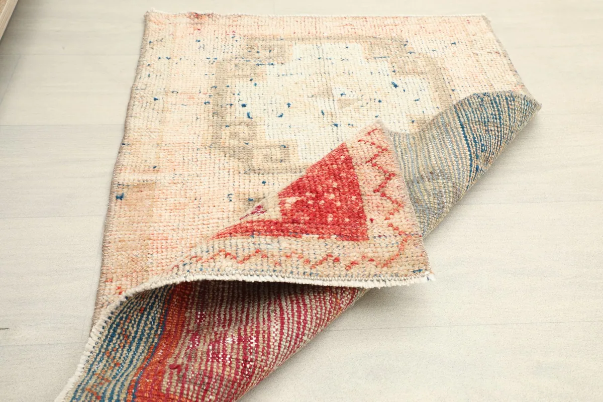 Angle view of the rug partially folded, showcasing the reverse side's construction and color distribution.