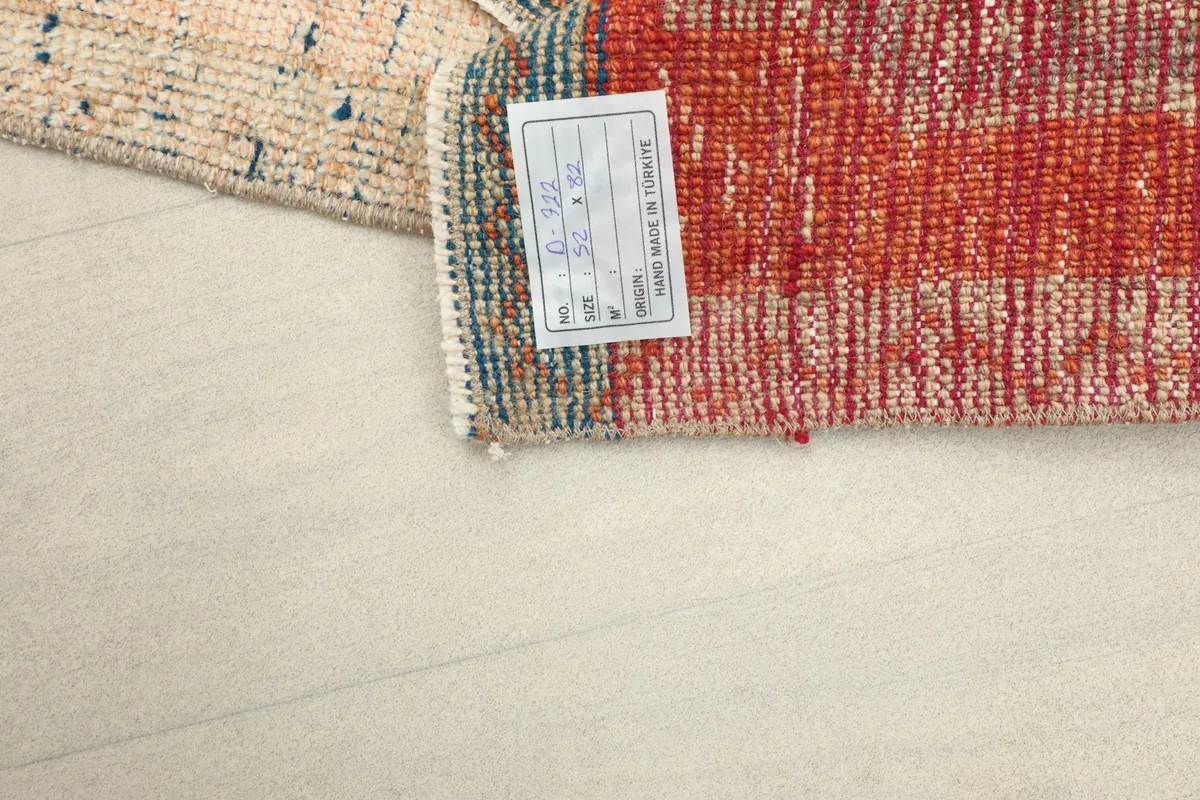 The back of the rug with its product tag, showing origin and material details.