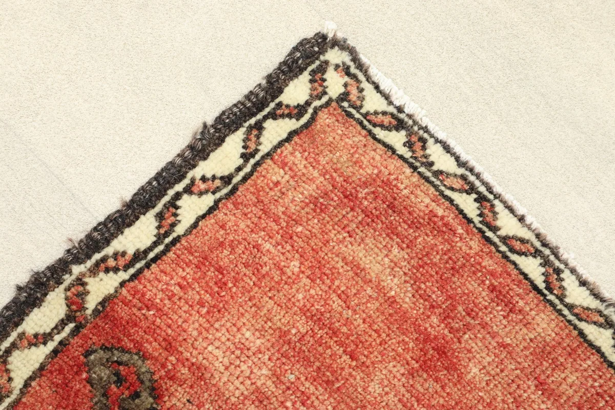 Close-up view of the corner, showing the red field and the beige and black border design.