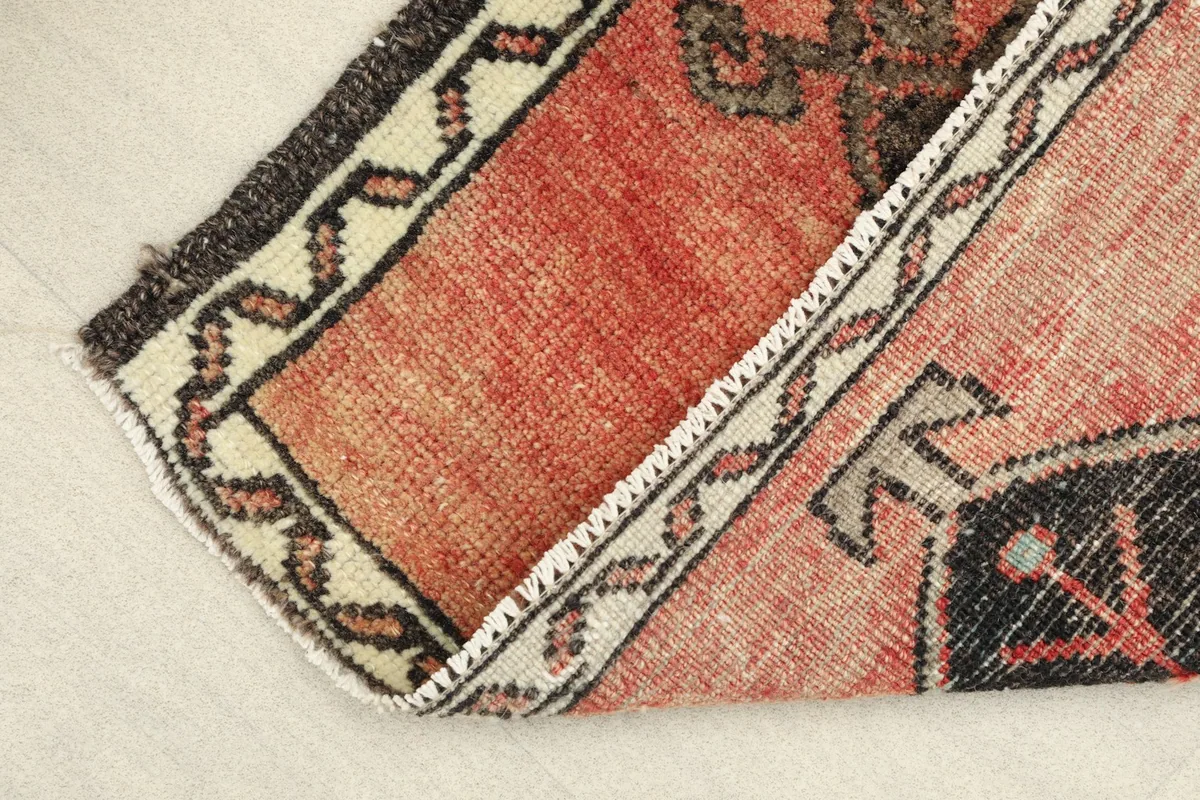 The rug folded to reveal the backside and the hand-knotted construction along the edge.