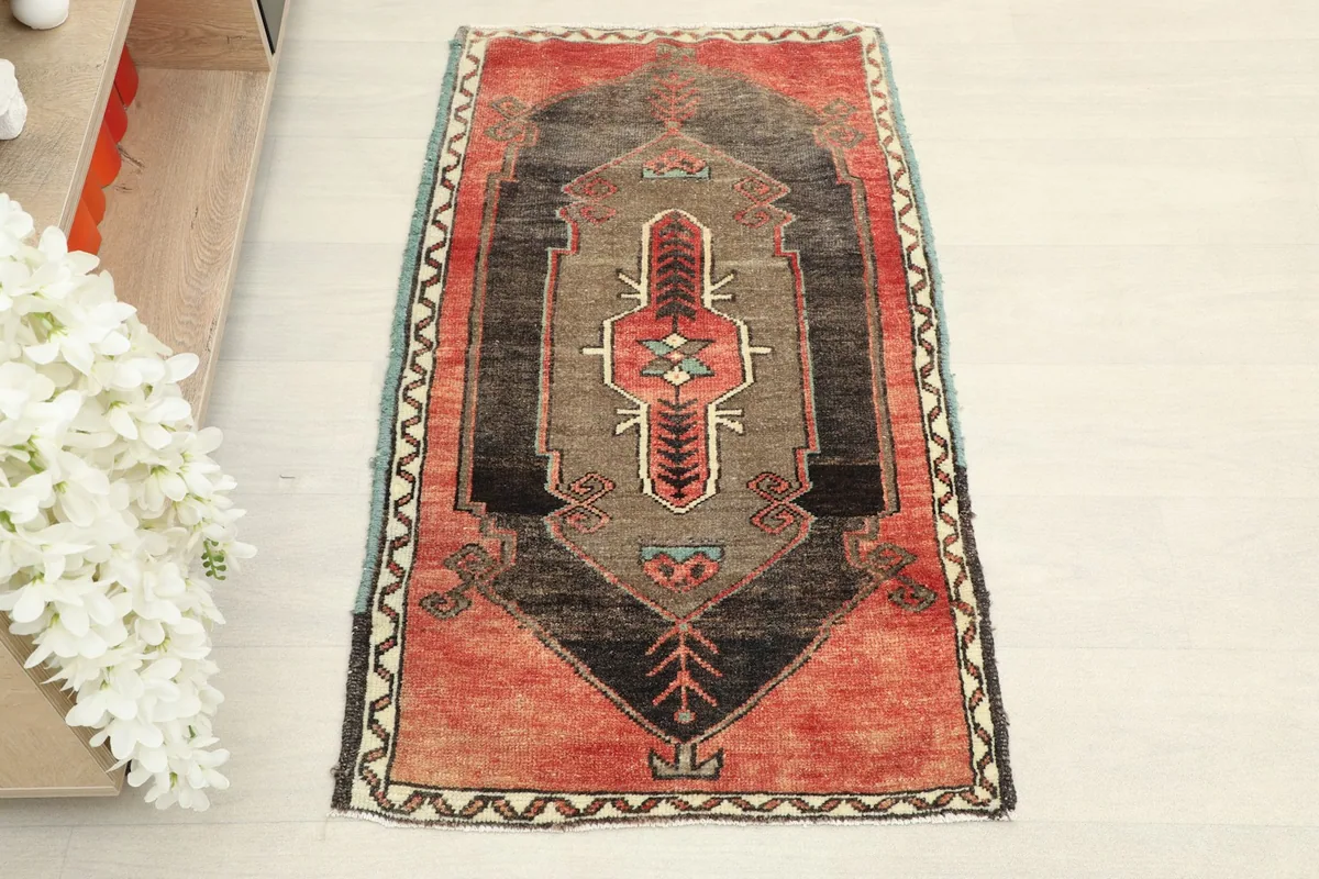 Overhead view of the red and brown vintage rug, showcasing its full design and colors.