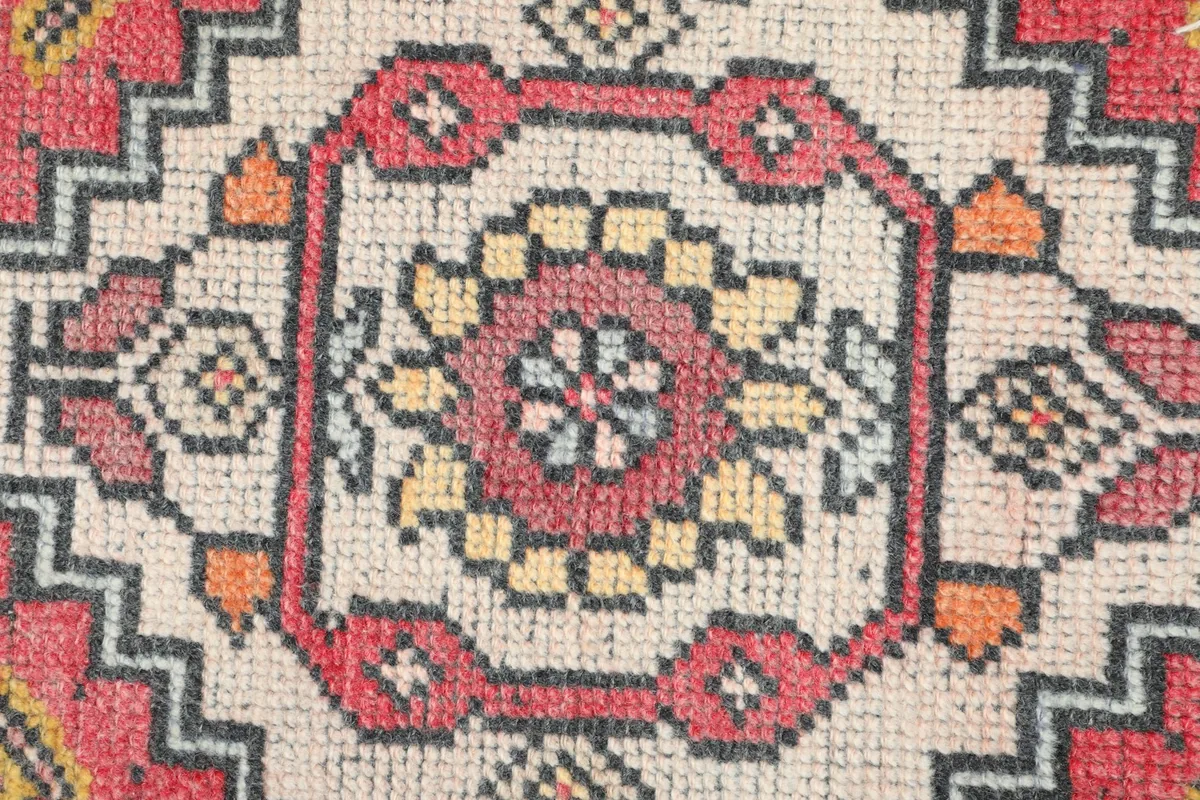 Detailed view of the intricate hand-knotted wool pile in the rug's central medallion