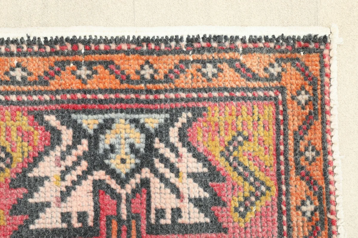 Close-up of the side border, showcasing the orange, charcoal, and yellow tribal motifs