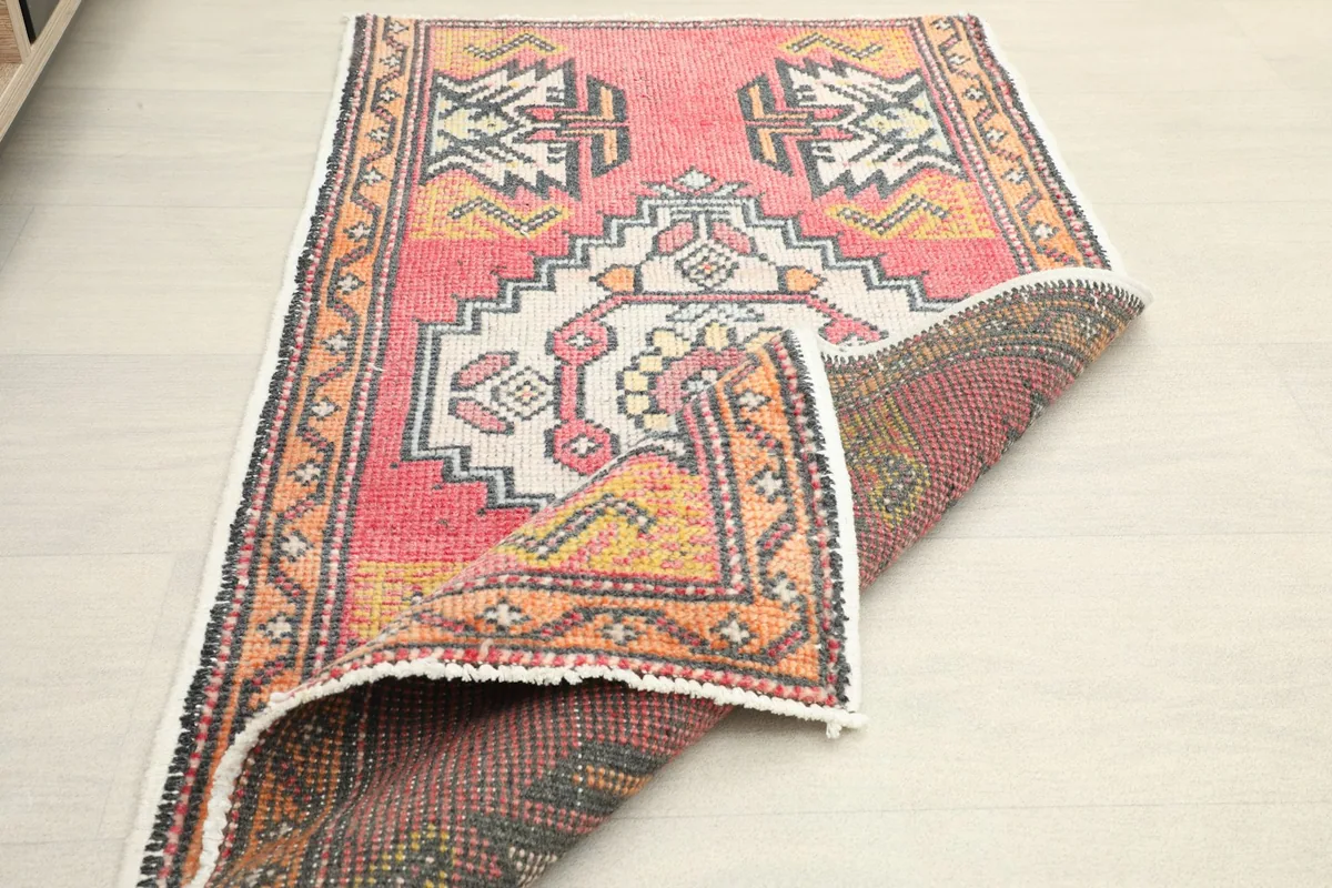 Partial fold of the rug revealing the tightly woven cotton foundation and hand-knotted construction