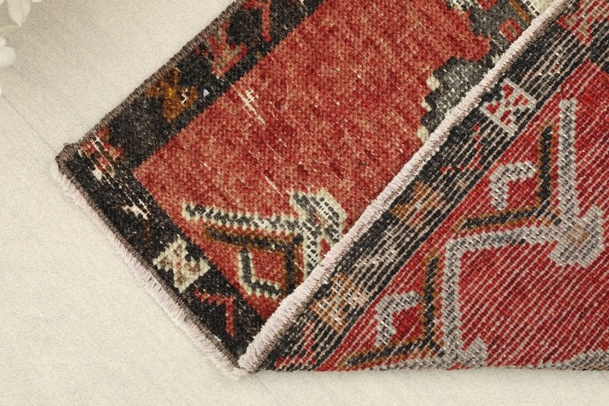View of the rug folded, showing the thickness of the wool pile and the construction.