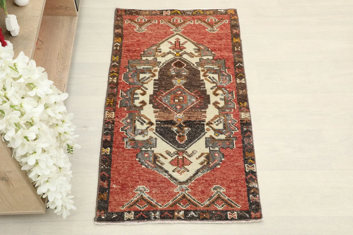 Direct overhead shot of the hand-knotted rust and cream rug, showing its full geometric pattern.