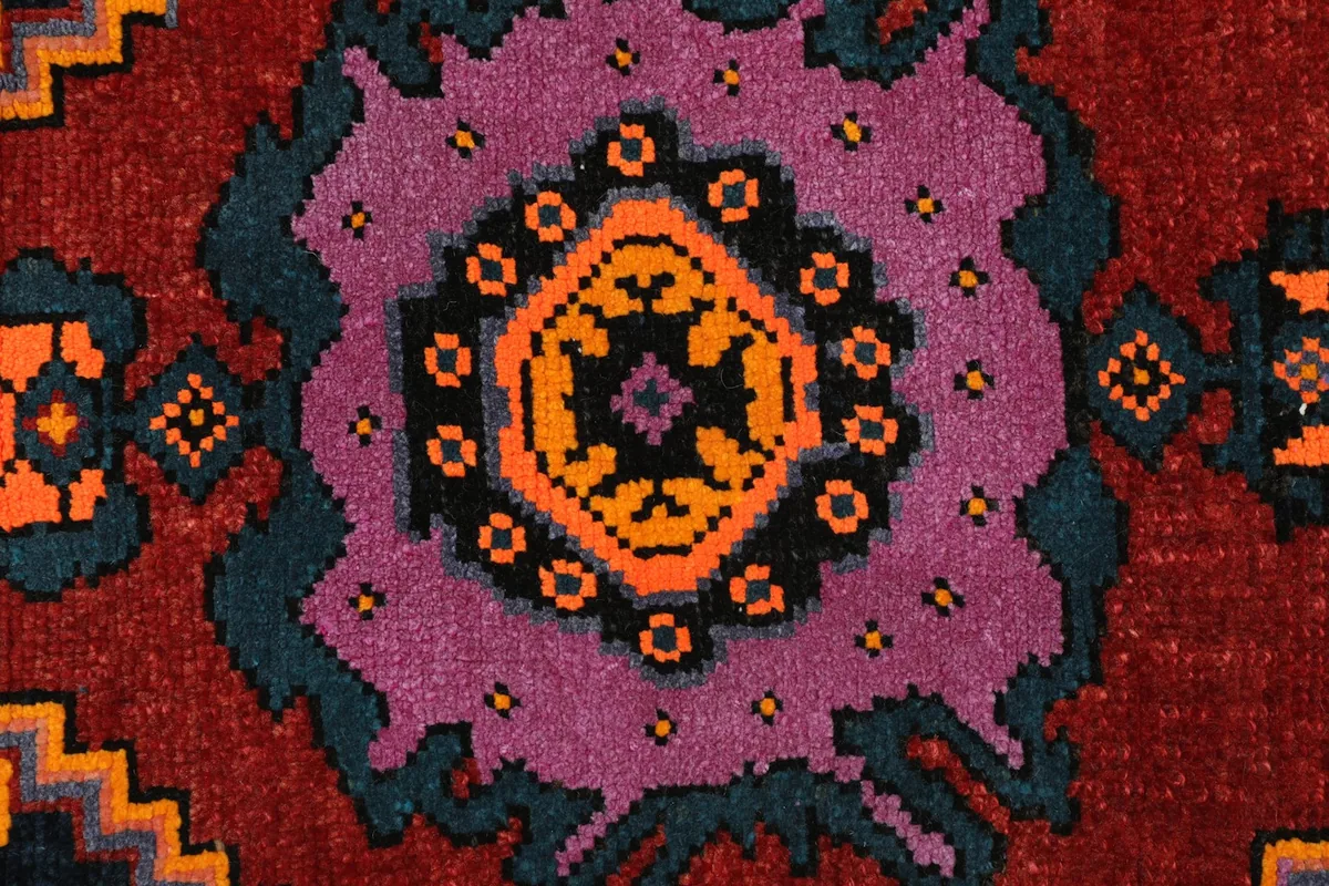 Detailed view of the intricate tribal motifs and color variations within the rug's design.