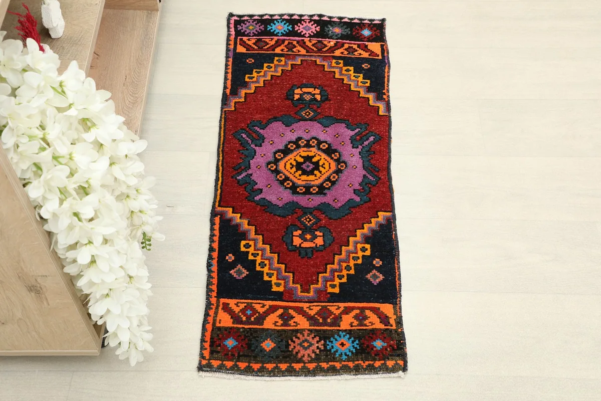 Overhead view of the hand-knotted red and navy runner, highlighting its geometric patterns.