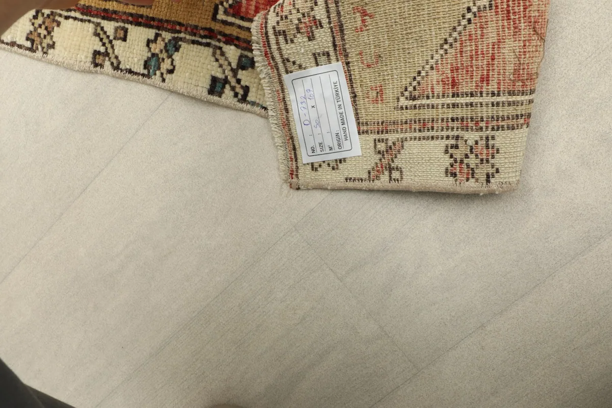 Underside of the rug with the label, showing the tightly woven cotton foundation.