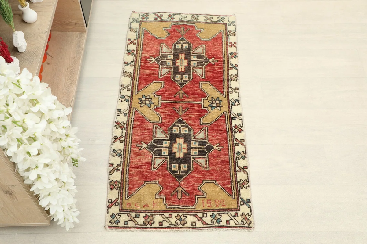 Top-down view of the hand-knotted red and tan Anatolian rug, highlighting its tribal geometric motifs.