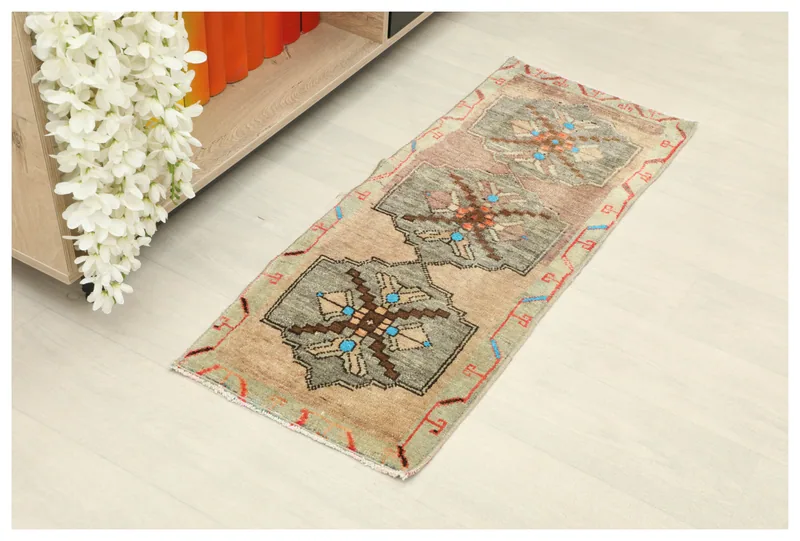 Full top view of the 1'5" x 3'6" beige and olive vintage Anatolian runner rug on a white background.